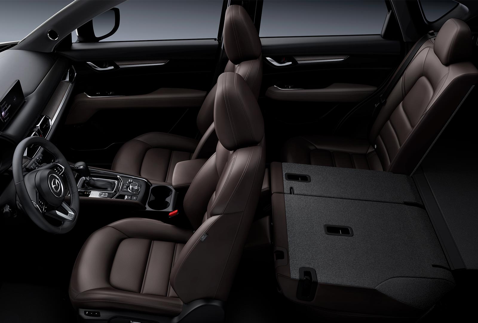 Front and rear seating view inside the CX-5, Cocoa leather upholstery with rear 60/40 seats folded. 