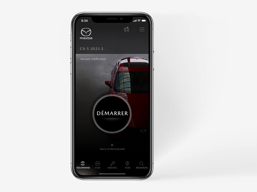 Téléphone noir montrant l’appli MyMazda avec le mot DÉMARRER dans un cercle superposé sur un Mazda CX-5