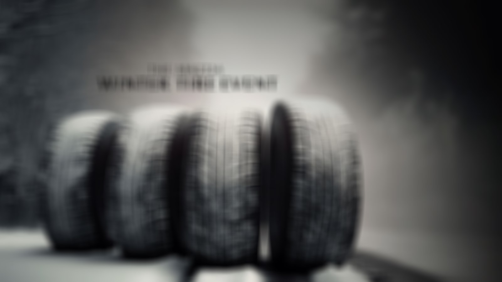 A set of four winter tires on a snowy background