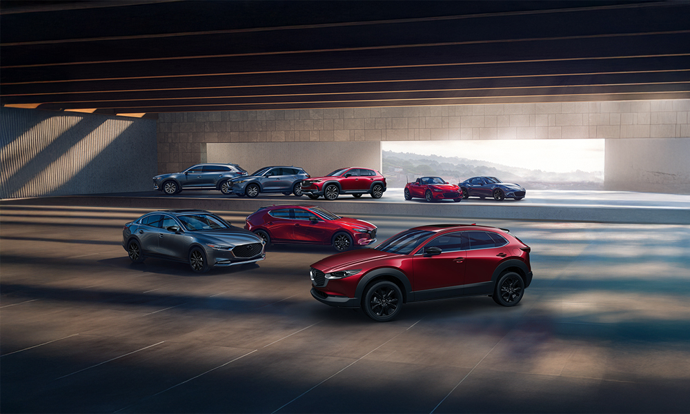 Salle d’exposition présentant un exemplaire de chaque modèle de Mazda en rouge vibrant cristal et bleu éternel mica