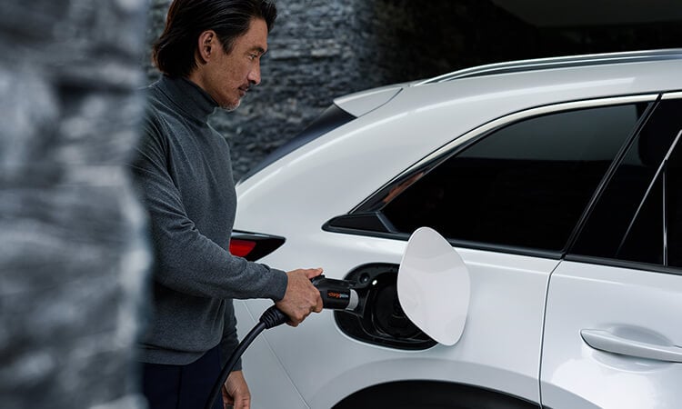 Driver approaches Mazda with level 2 charger in hand.