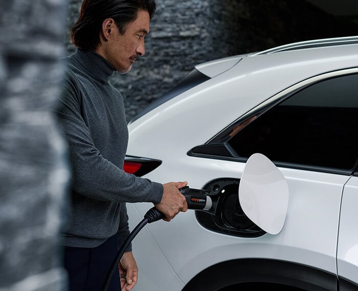 Driver approaches Mazda with level 2 charger in hand.