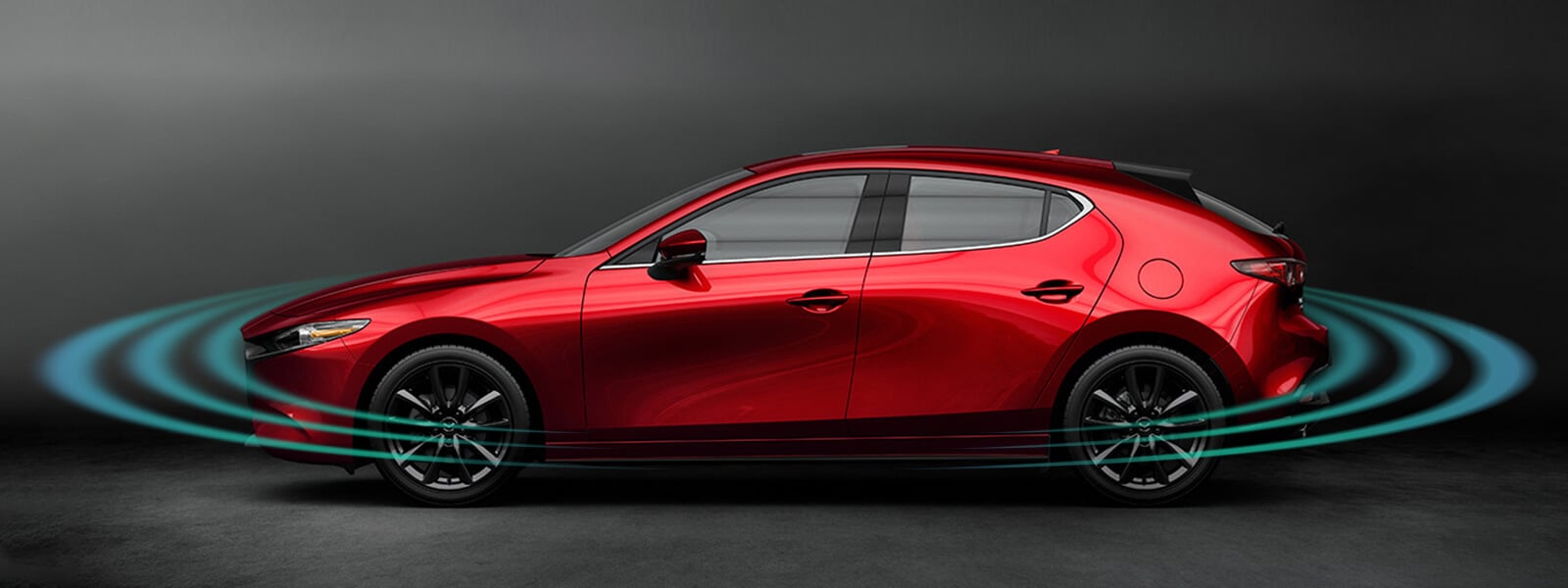Plan flou côté passager arrière d’une Mazda3 rouge sur l’autoroute, avec des impulsions radar rayonnant vers l’avant et l’arrière.