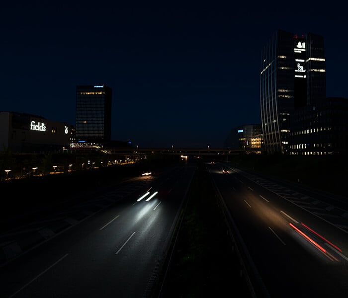 Urban highway at night showing blurred head and taillights