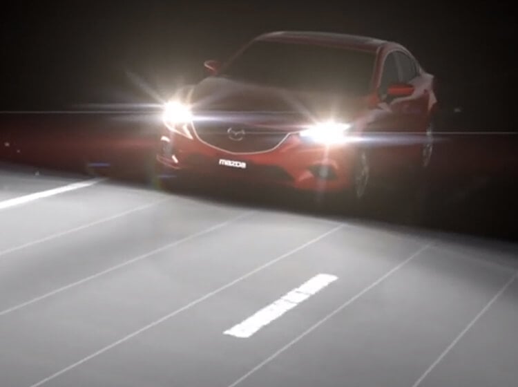 Soul Red Crystal Mazda3 Sport driving at night with high beams on.