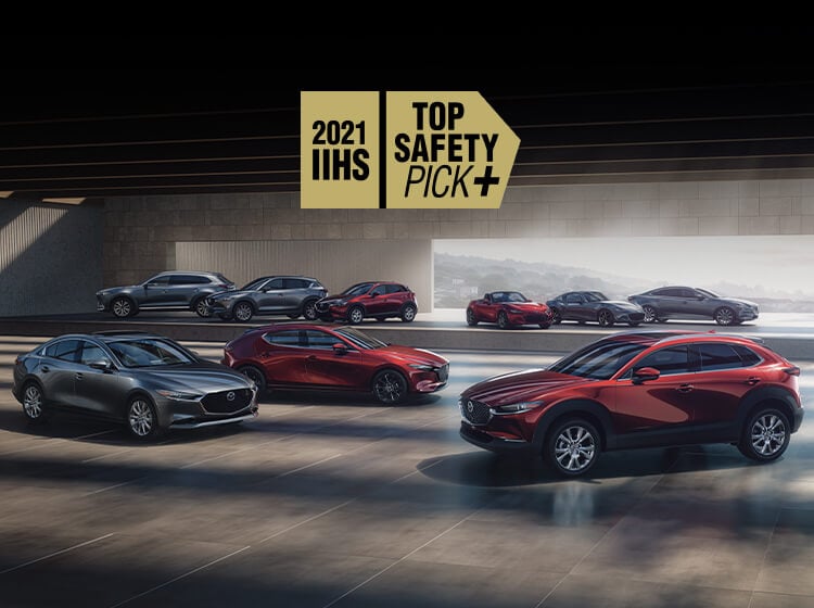 Showroom floor featuring all Mazda car models in either red or grey. 