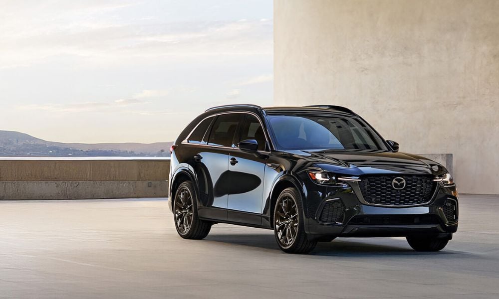 White CX-70 PHEV parked at a charging station.