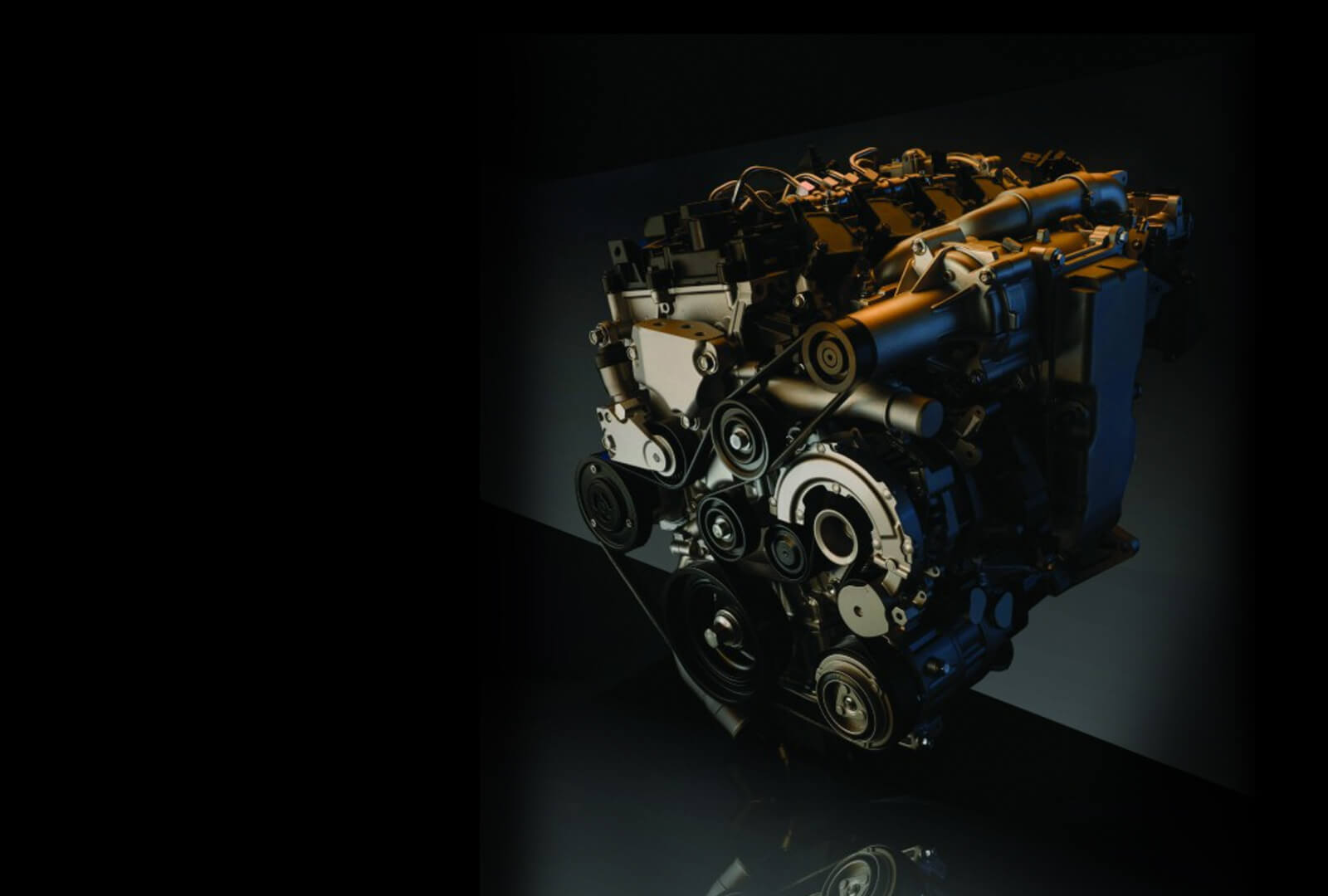Skyactiv engine from elevated three quarter view against a black and gray background.