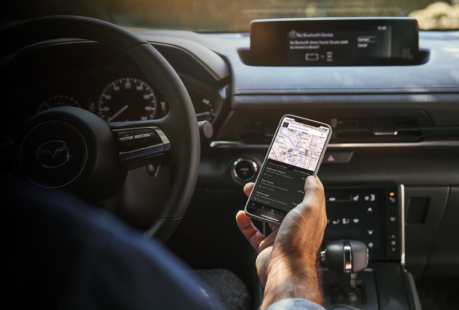 Propriétaire Mazda connectant son téléphone à la voiture.