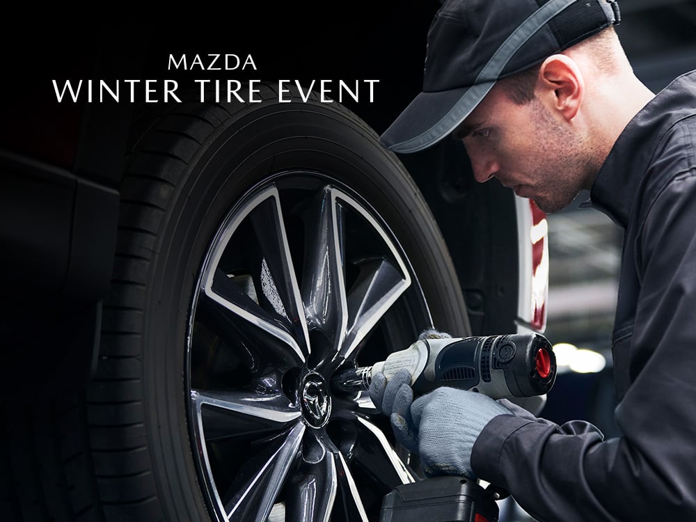Mazda technician tightening lug nuts on wheel of vehicle