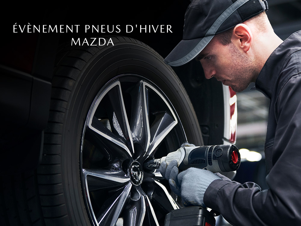 Un technicien Mazda serrant les écrous de roue sur la roue du véhicule