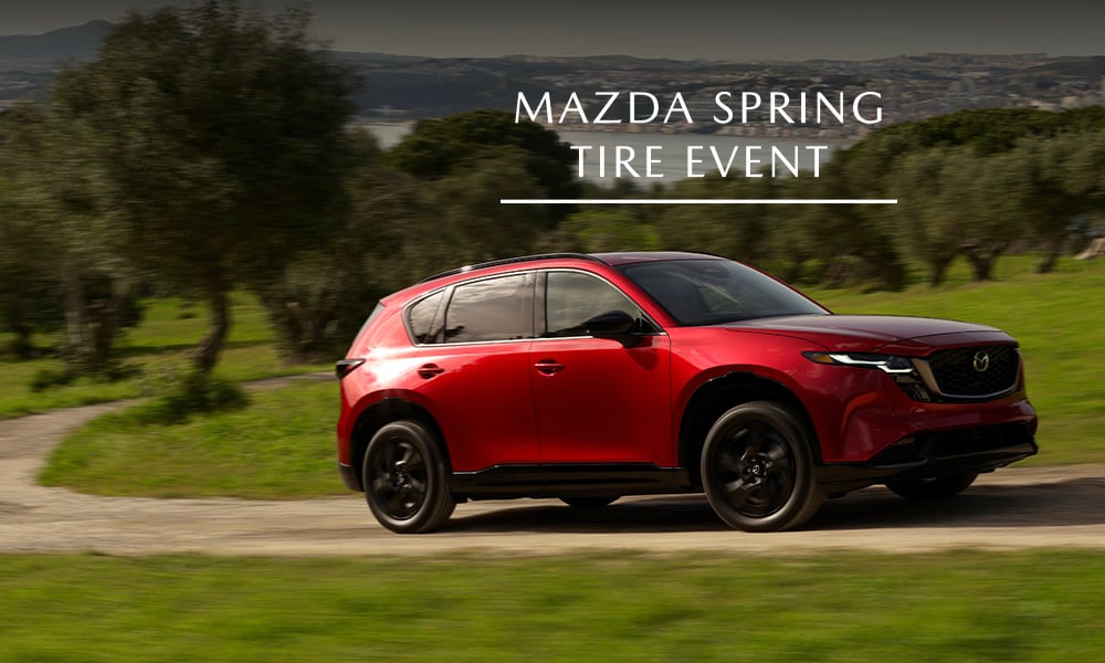 A red Mazda CX-5 parked on a grassy field
