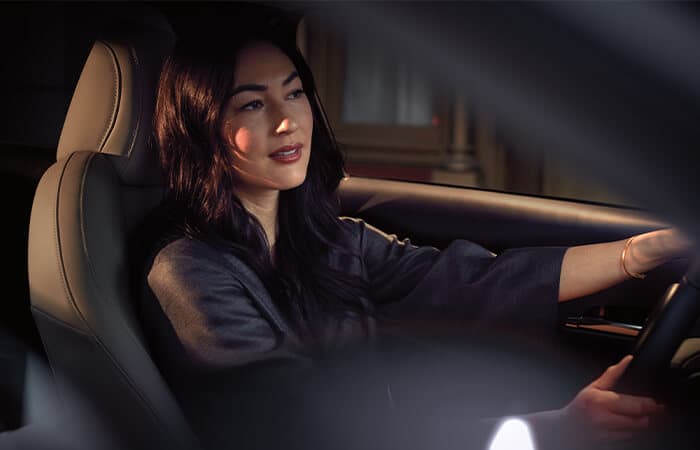 Close-up of relaxed-looking woman driving.