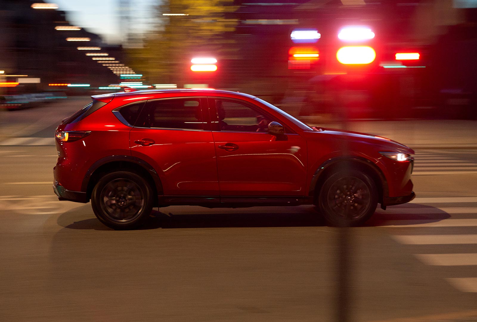 Soul Red Crystal CX-5 blurred profile as it moves along urban street. 