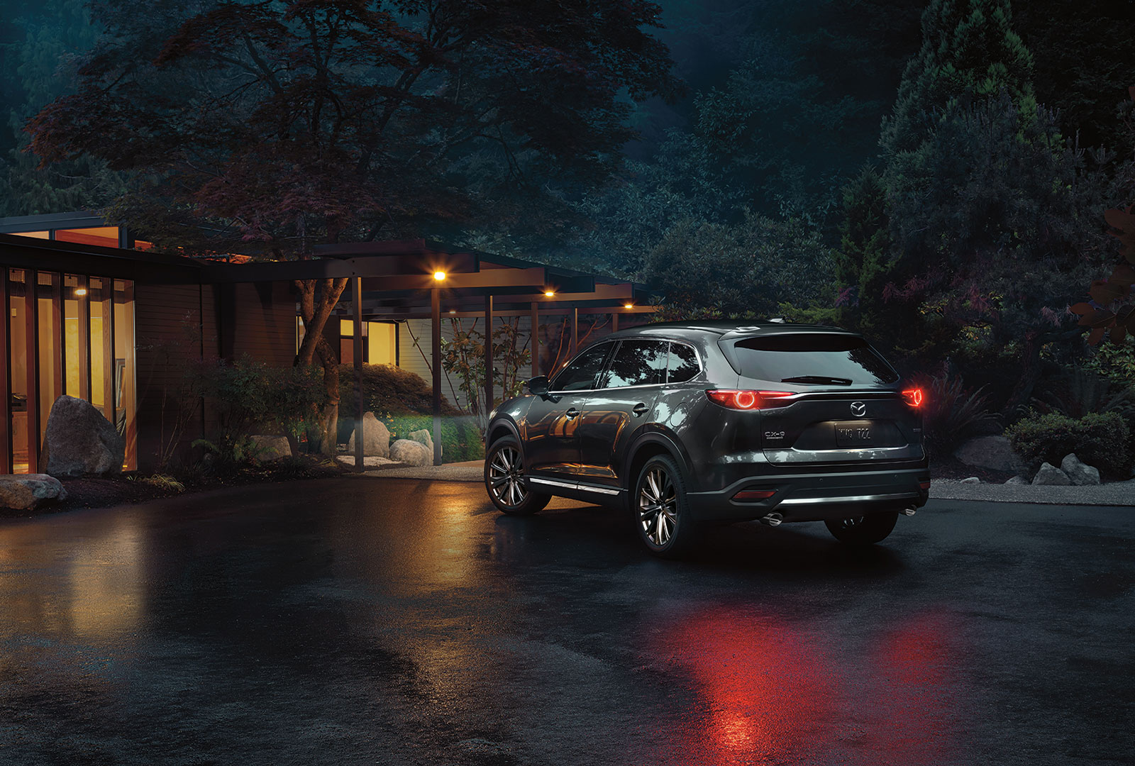 Mazda CX-9 parked in front of a cabin at night.
