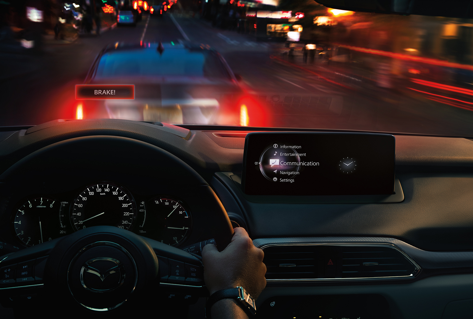 Active Driving Display projects the word “BRAKE!” onto windshield with illuminated brakelights of vehicle ahead visible.