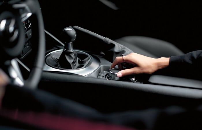 Female driver’s hand adjusts HMI Commander control switch.