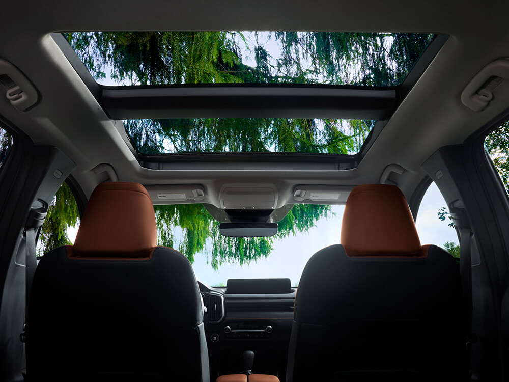 Interior upward view of terracotta leather seats and moonroof.