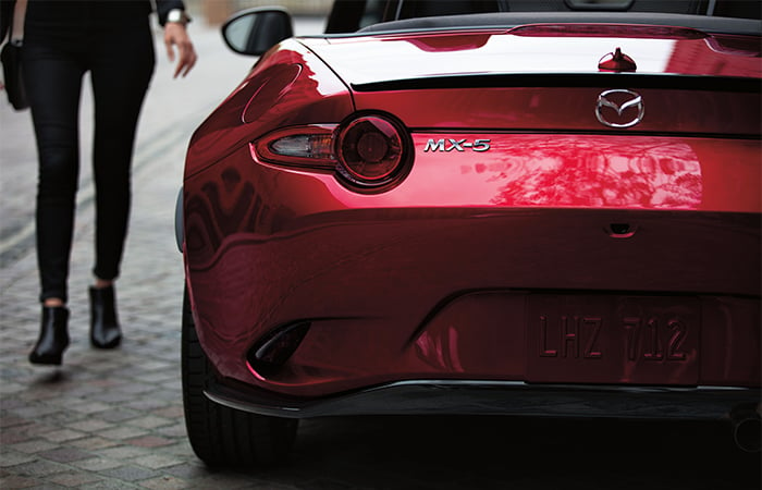 Close-up of left MX-5 taillight as a driver approaches from in front of the vehicle.