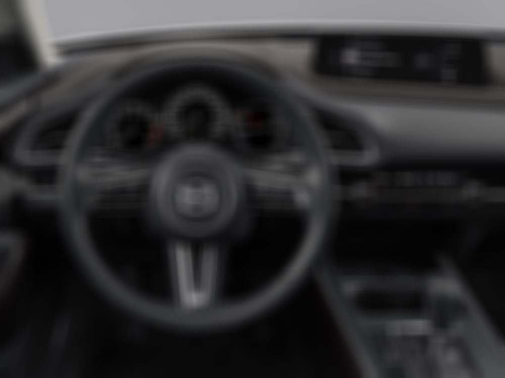 Interior shot of steering wheel, dash and control panel from CX-30 driver’s seat. 