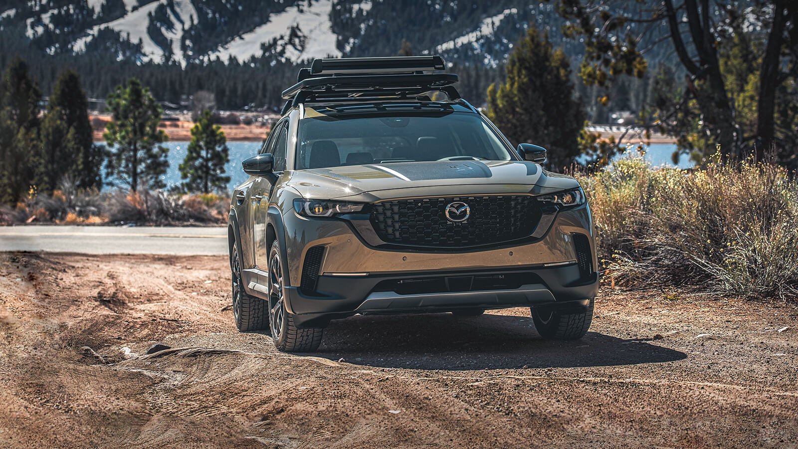 Meridian trim CX-50 drives off a paved road and onto a craggy dirt path.