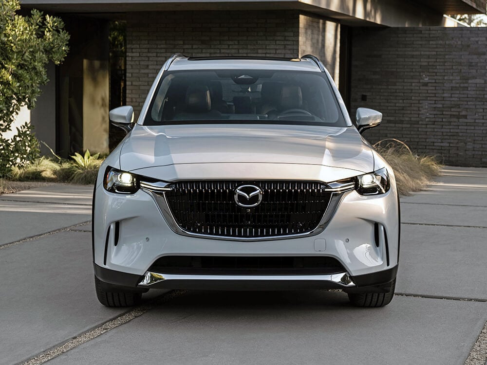 Arctic White CX-90 front grille and headlights at sundown.  