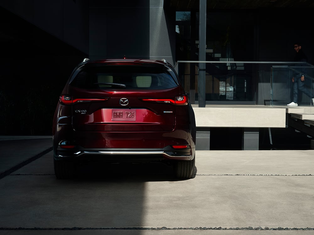 CX-90 rear liftgate ajar reveals cargo space. 