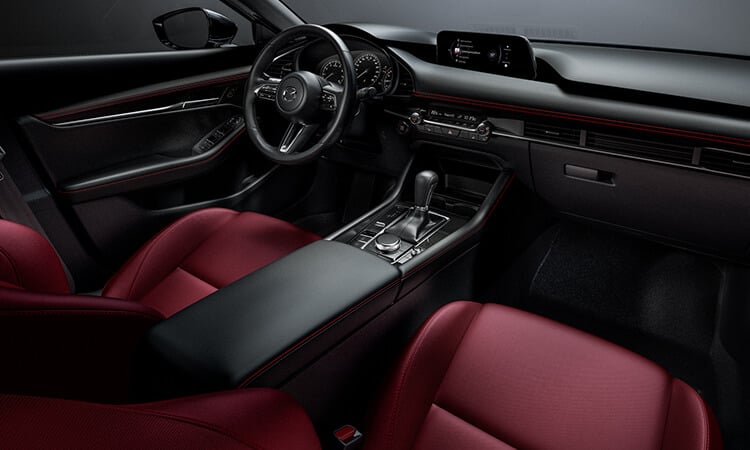 Une Mazda3 Sport dont l’habitacle est revêtu d’une sellerie en cuir rouge grenat. 
