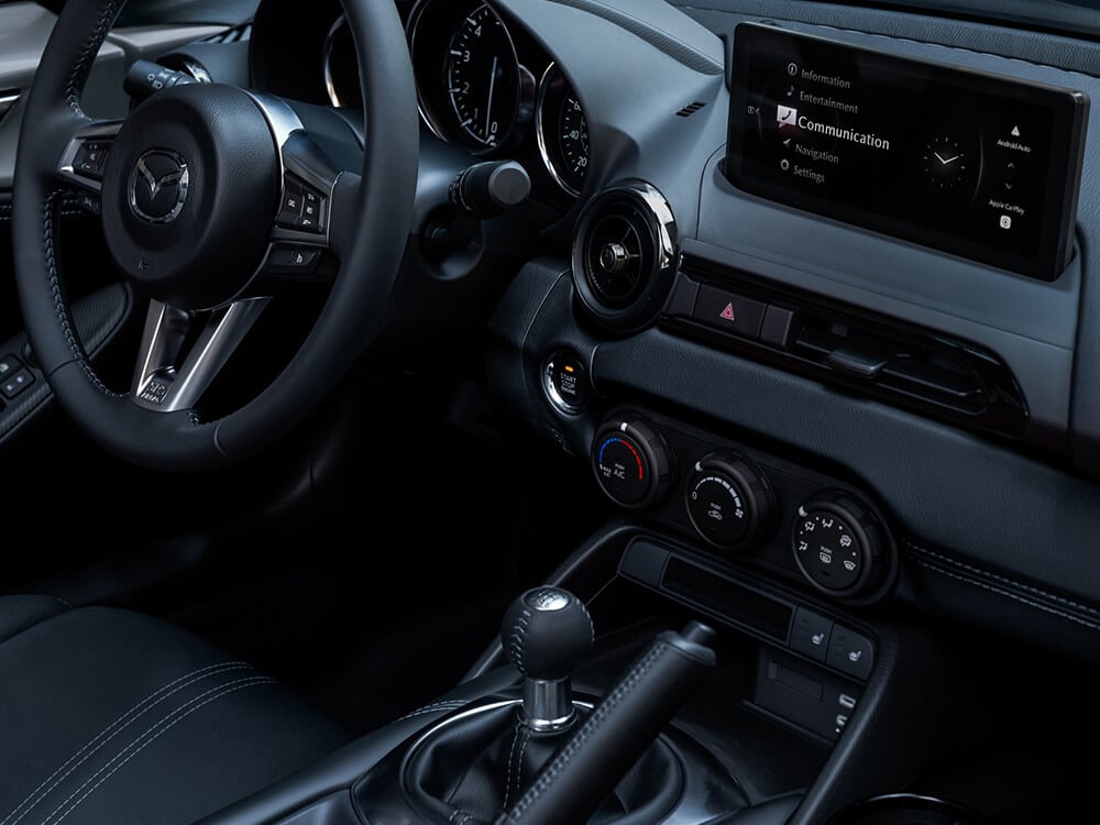 Interior shot of the MX-5 ST from the passenger's side shows the Human Machine Interface around the centre console, the steering wheel and touchscreen display.