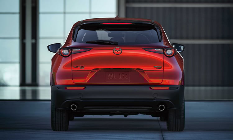 CX-30 driving on mountain road, view from inside, backseat looking forward at the driver and passenger in front seats.