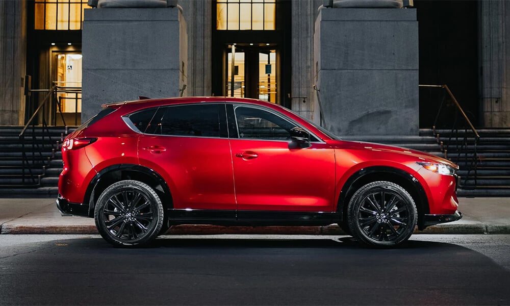 Soul Red Crystal Mazda CX-5 parked on city street, side profile view.