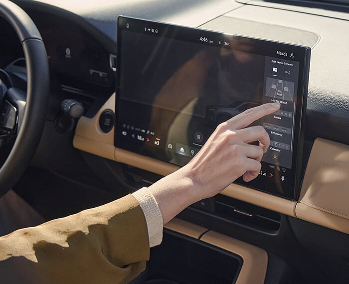 Hand using the Mazda CX-5 centre touchscreen display.