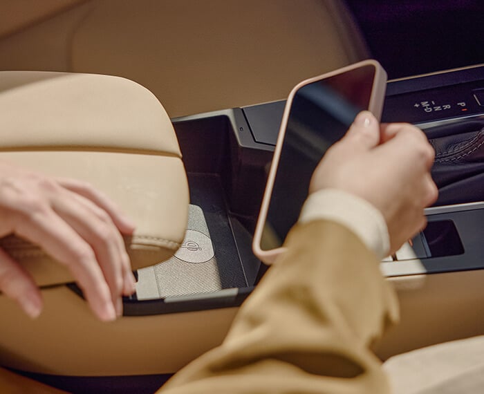 Hand taking a phone from the centre console of a Mazda CX-5.