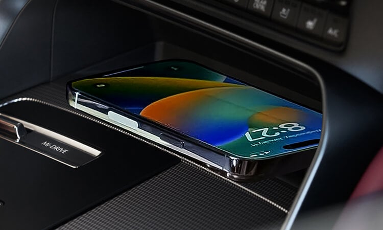 Smartphone lays charging on wireless charger in the centre console of the CX-70.