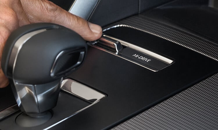 Driver’s finger toggling the Mi-Drive switch on the centre console inside CX-70.